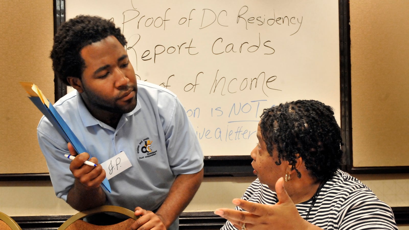 WASHINGTON DC JUNE 25: Opportunity Scholarship Program's JP Regis(L) listened as Elanie Cousins asked a question while filling out her application on June 25, 2011 in Washington, DC.(Photo by Mark Gail/The Washington Post via Getty Images)