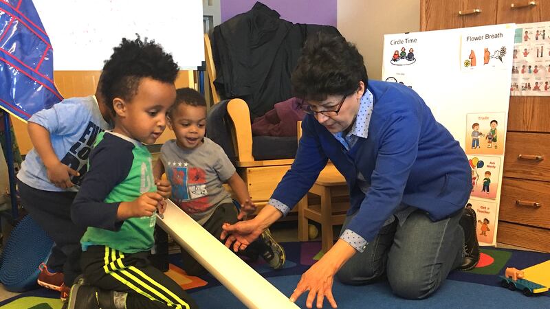 Sheryl Robledo, an early childhood coach, plays with preschool students at a Sewall Child Development Center site in far northeast Denver.