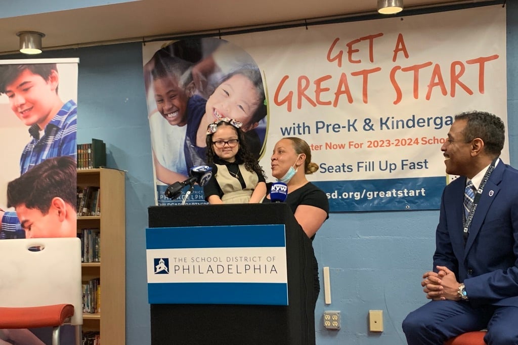 Jasmine DeJesus and her daughter Mia urge families to register their children early for kindergarten as Philadelphia school superintendent Tony Watlington looks on.