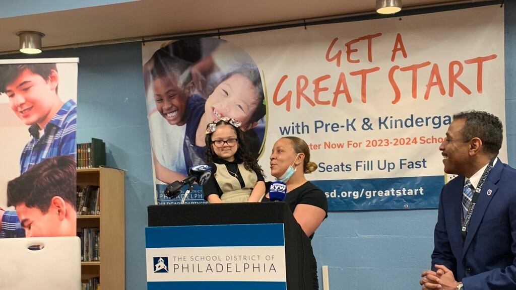 Jasmine DeJesus and her daughter Mia urge families to register their children early for kindergarten as Philadelphia school superintendent Tony Watlington looks on.