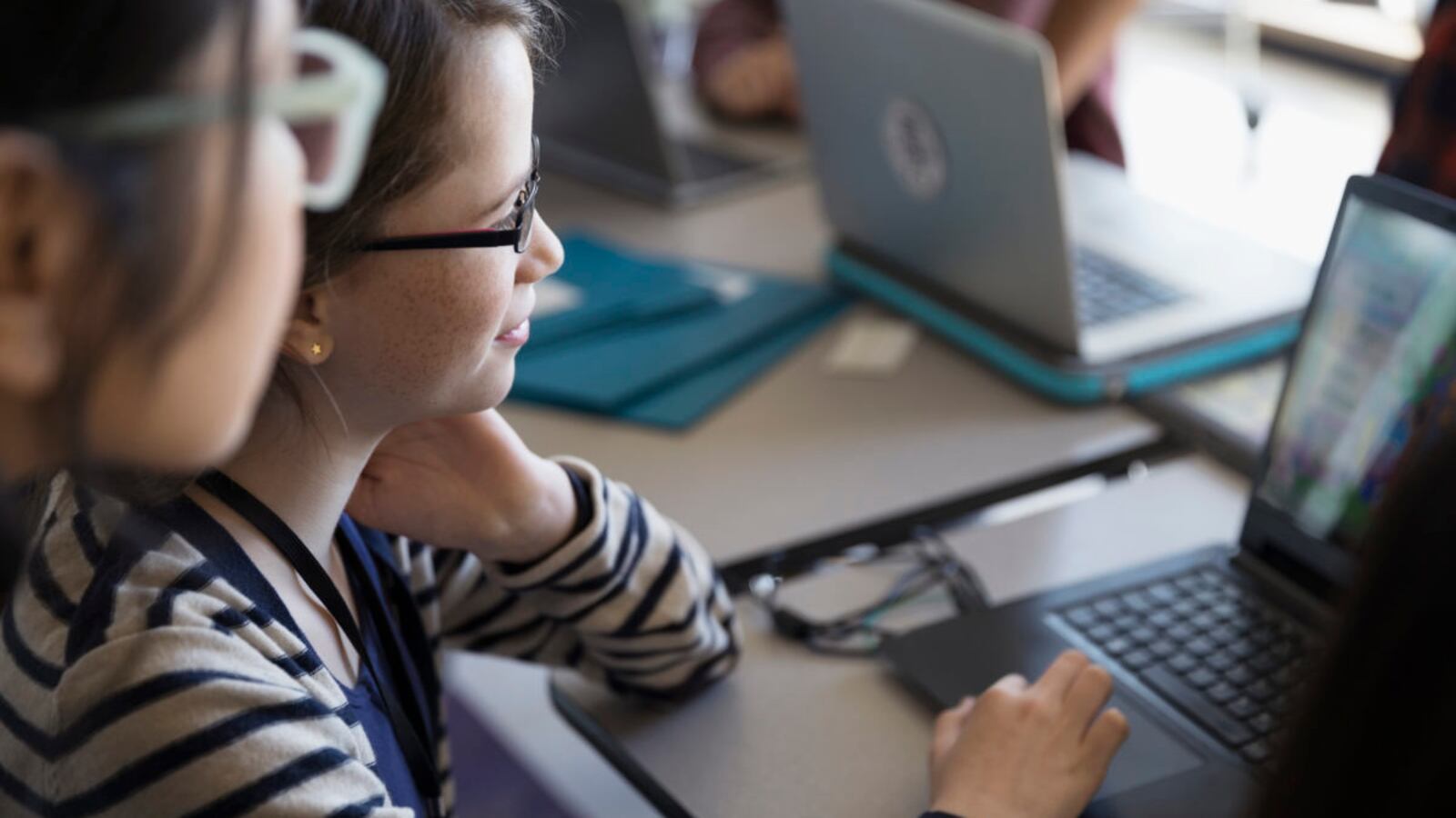 Girl using laptop in classroom.