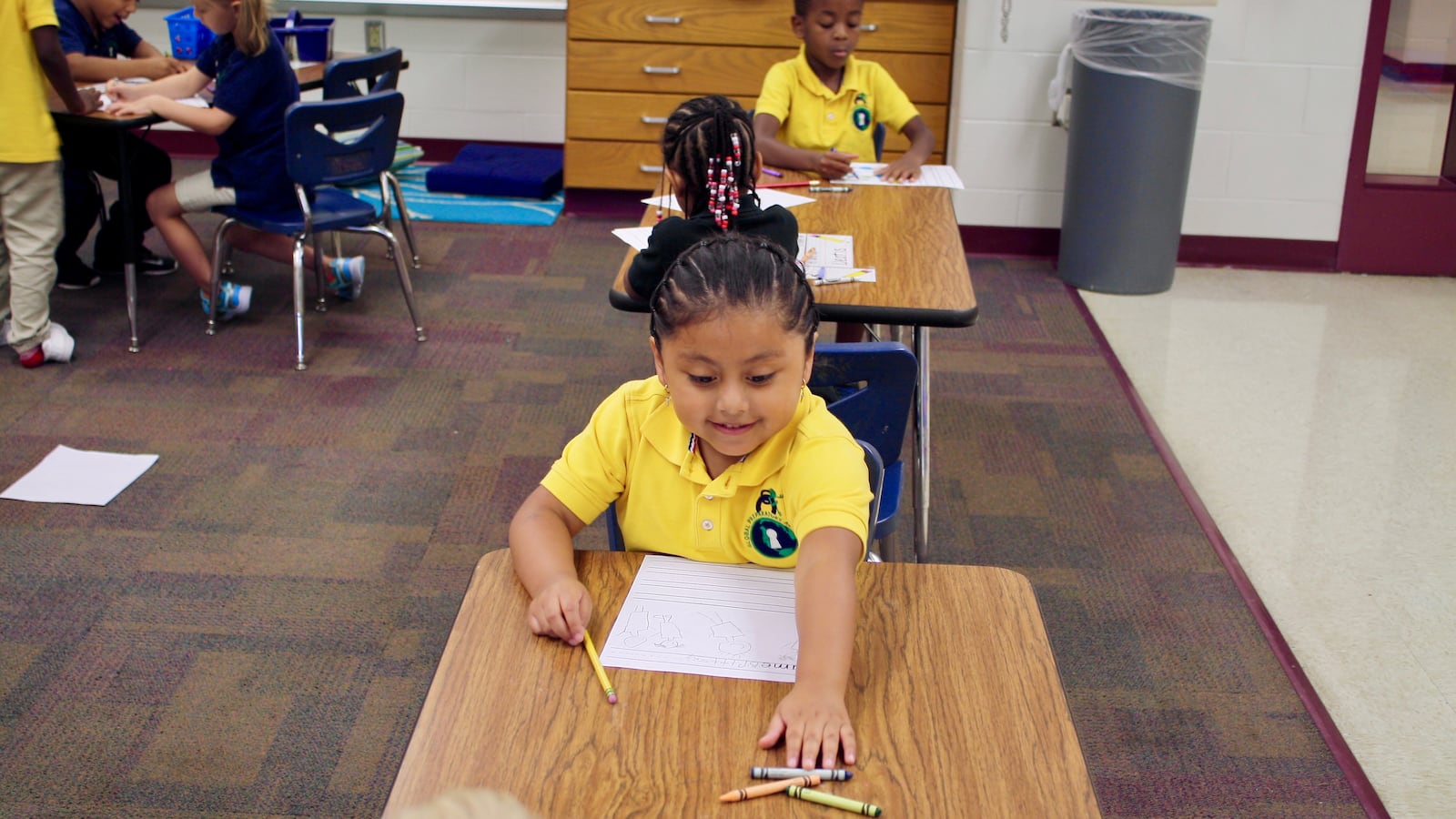 A kindergarten student reaches for crayons during a lesson at Global Prep Academy. The school has a Spanish dual language program for grades K-2.