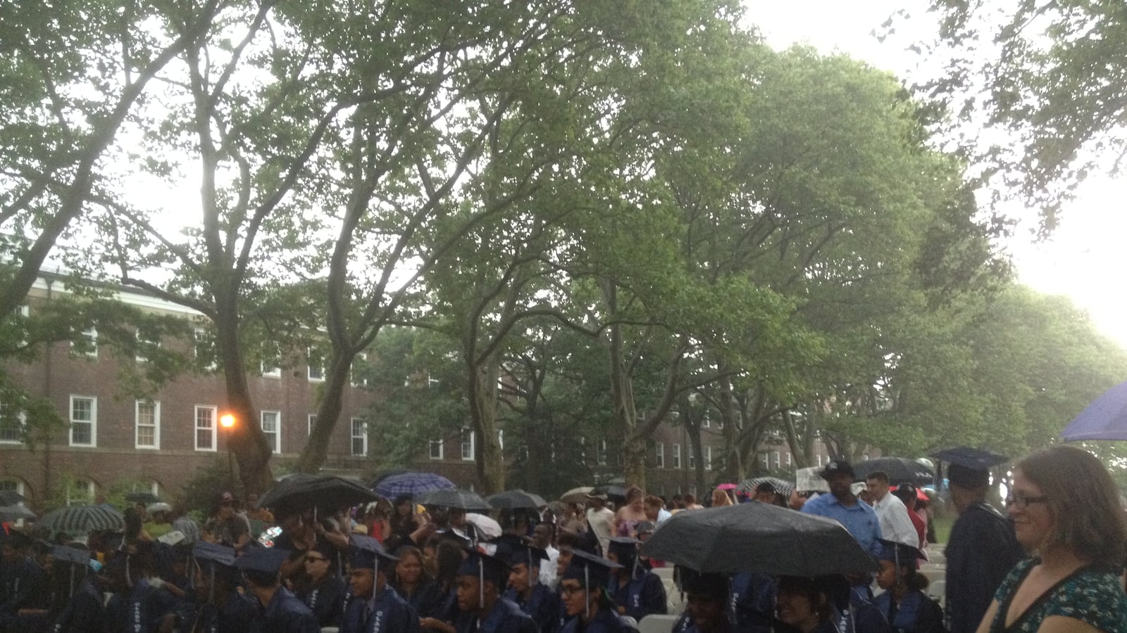 Students listened to their valedictorian in the rain, before lightning caused the ceremony to be moved inside.