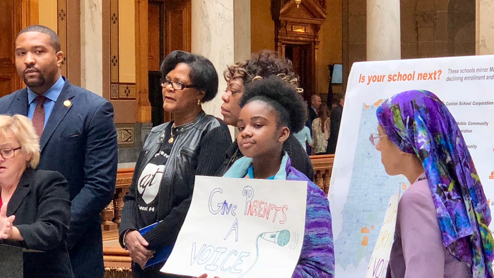 Students hold signs against a bill in the legislature that would allow a state takeover of the Gary and Muncie school districts.