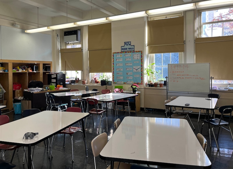 An empty classroom with large desks in the middle