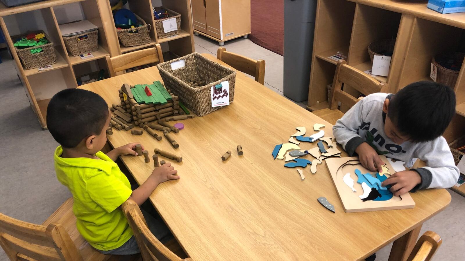 Two preschool children work at a puzzle table in Chicago.