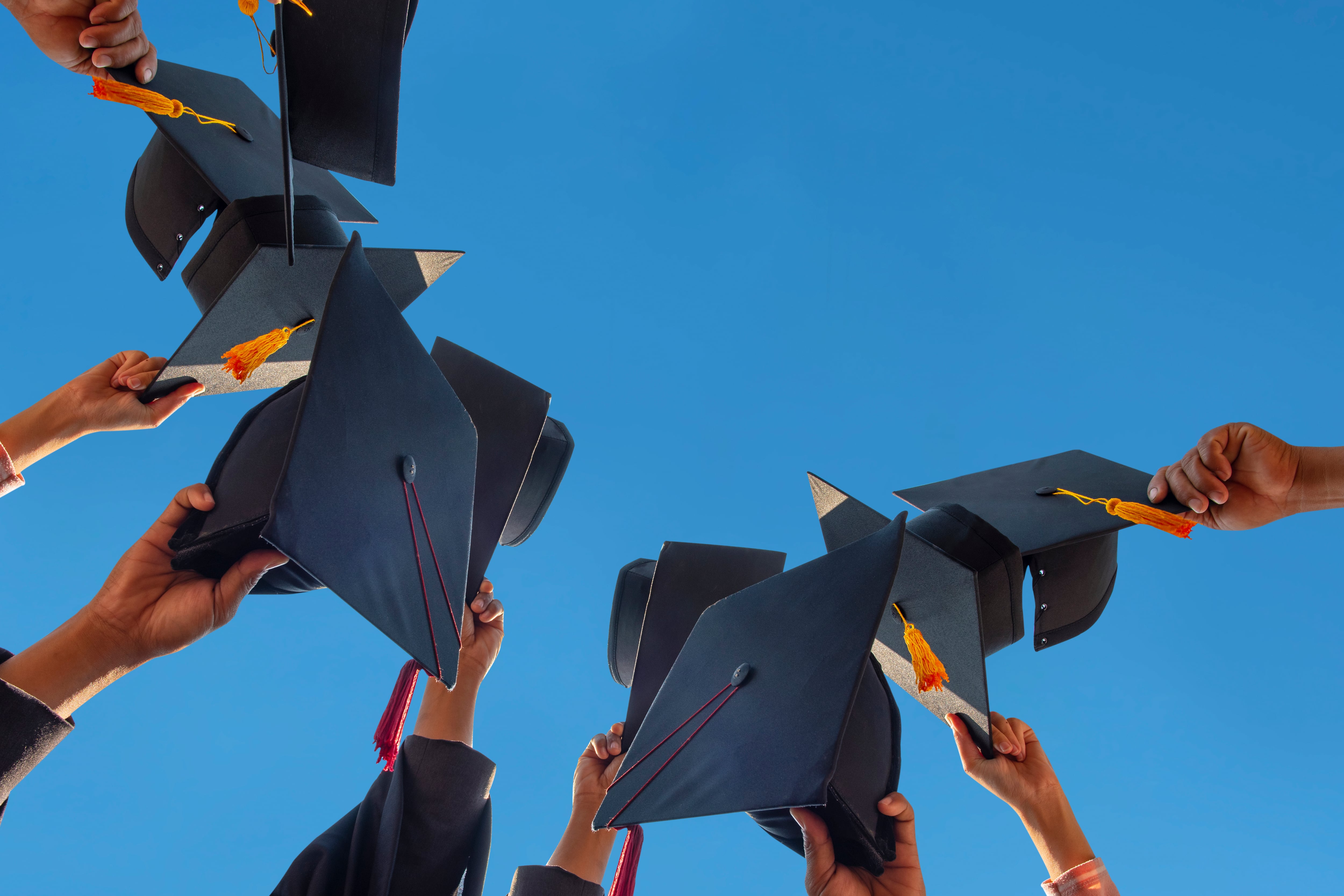 Graduation caps held up