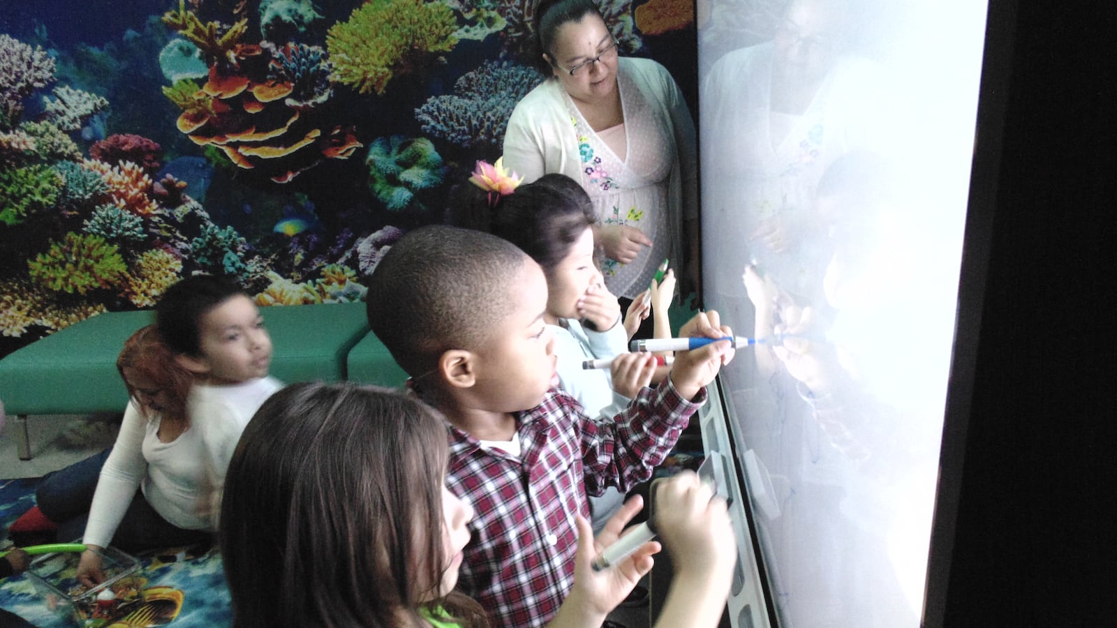 Children at one of El Valor's early learning centers work on a smart board. Community providers say they want to compete for preschoolers with city schools in the universal pre-K rollout.