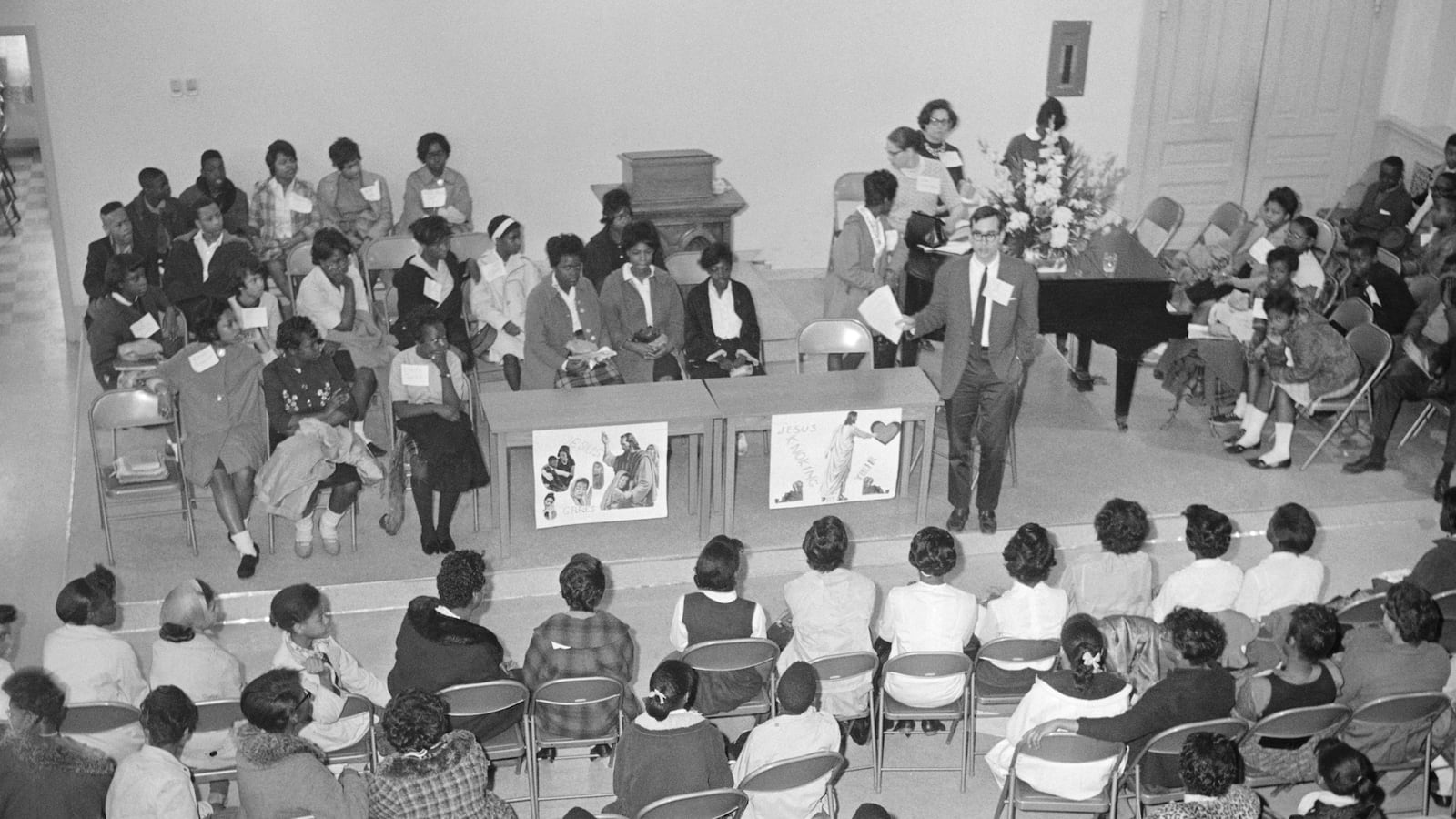 A group of students and teachers gather in a church that is being used as a makeshift school.