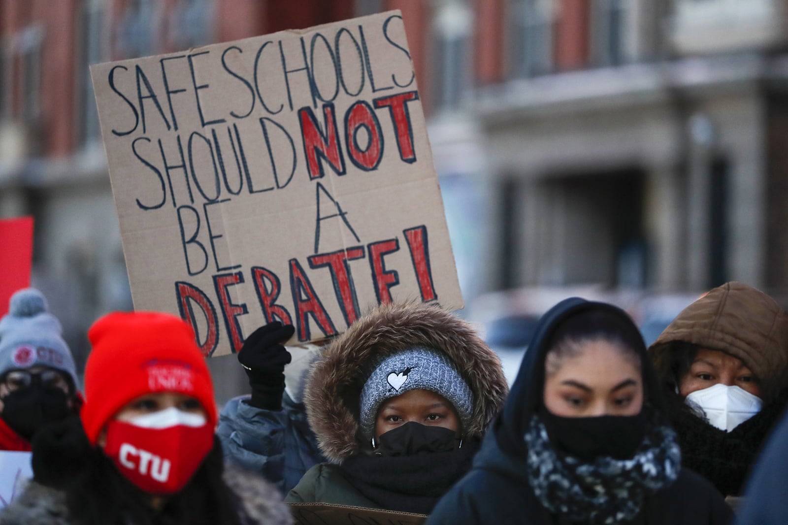 Chicago educators in hats and coats on a winter day gather at a morning press conference during the standoff that closed schools to Chicago students for five days.
