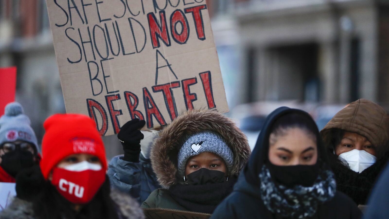 Chicago educators in hats and coats on a winter day gather at a morning press conference during the standoff that closed schools to Chicago students for five days.