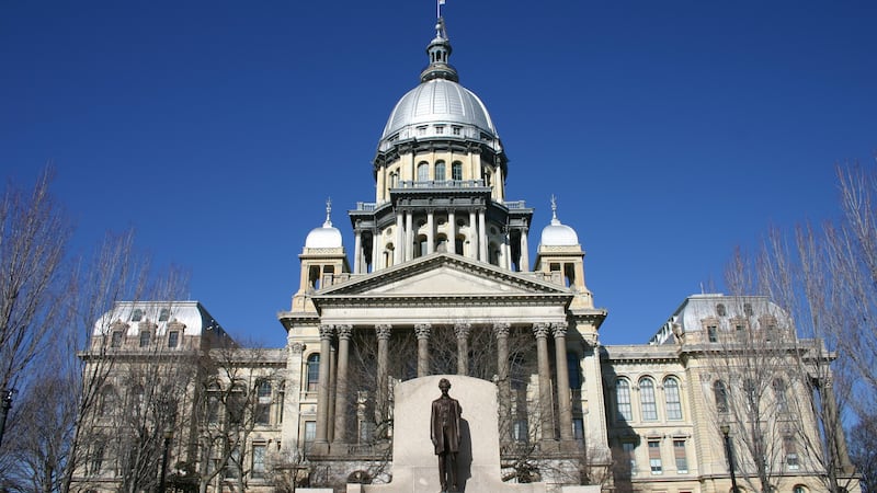 Illinois State Capitol Building with Abraham Lincoln statue and a clear blue sky.