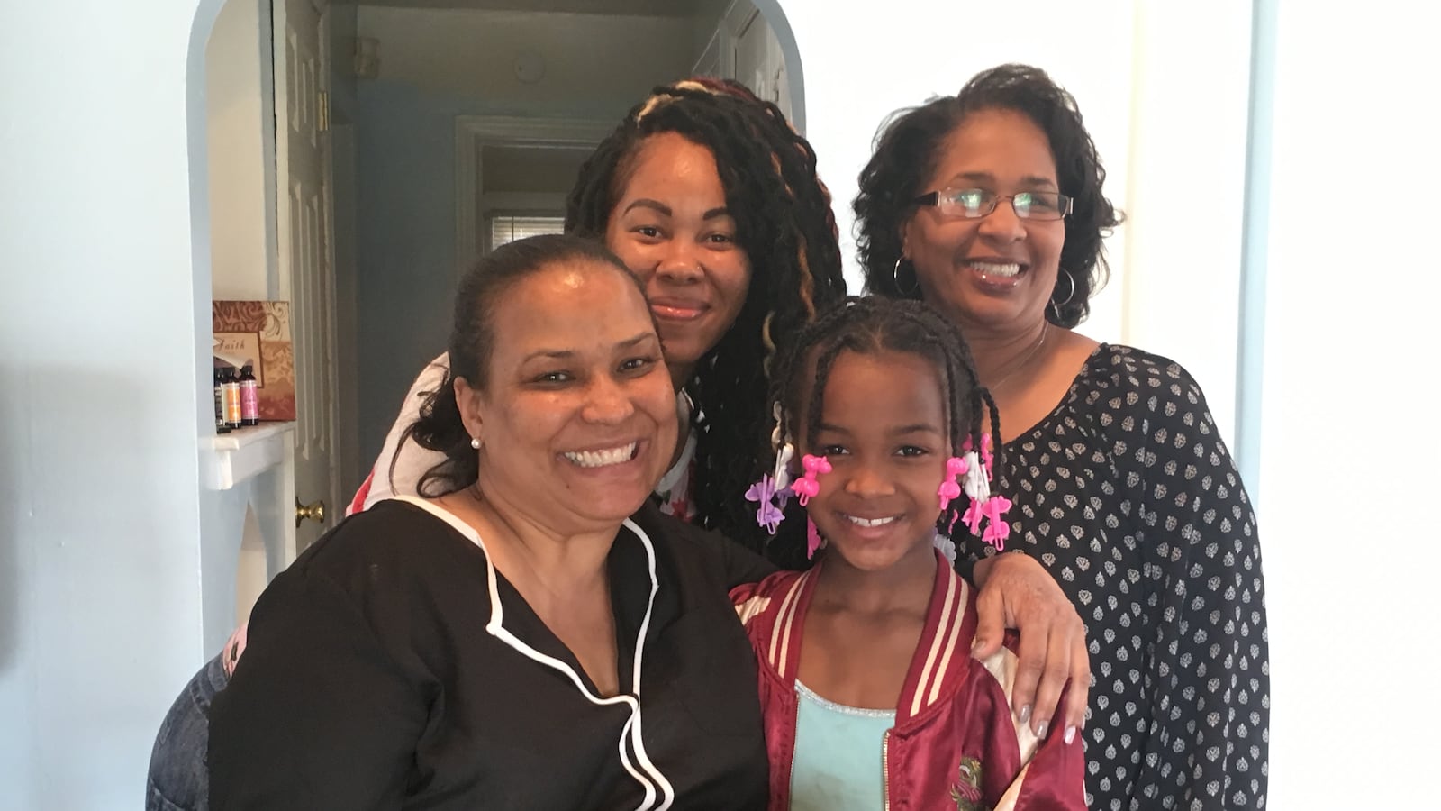 Coleman A. Young Elementary School Principal Melissa Scott (left) and teacher Melanie Wallace (right) paid a visit to the home of Brenda Hutchins and her daughter Samantha Hutchins to discuss ways the school can help the family succeed. “We see how hard you’re working, mama!” Scott told her.