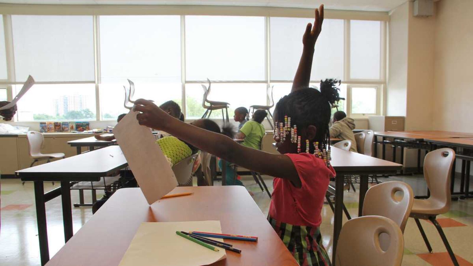 Young student raising her hand.