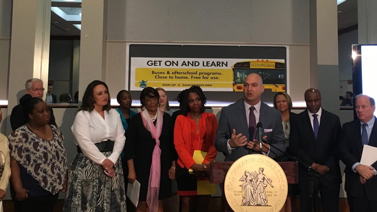Superintendent Nikolai Vitti speaks about a bus route that will carry district and charter school students in northwest Detroit. Charter operator Ralph Bland and Mayor Mike Duggan stand at his right.