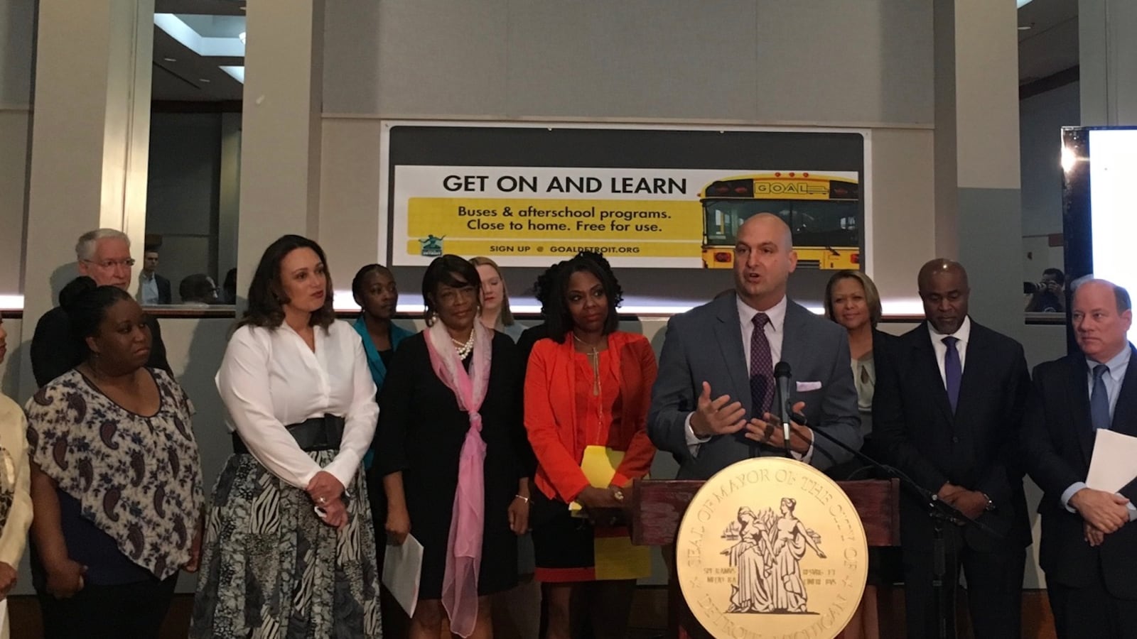Superintendent Nikolai Vitti speaks about a bus route that will carry district and charter school students in northwest Detroit. Charter operator Ralph Bland and Mayor Mike Duggan stand at his right.