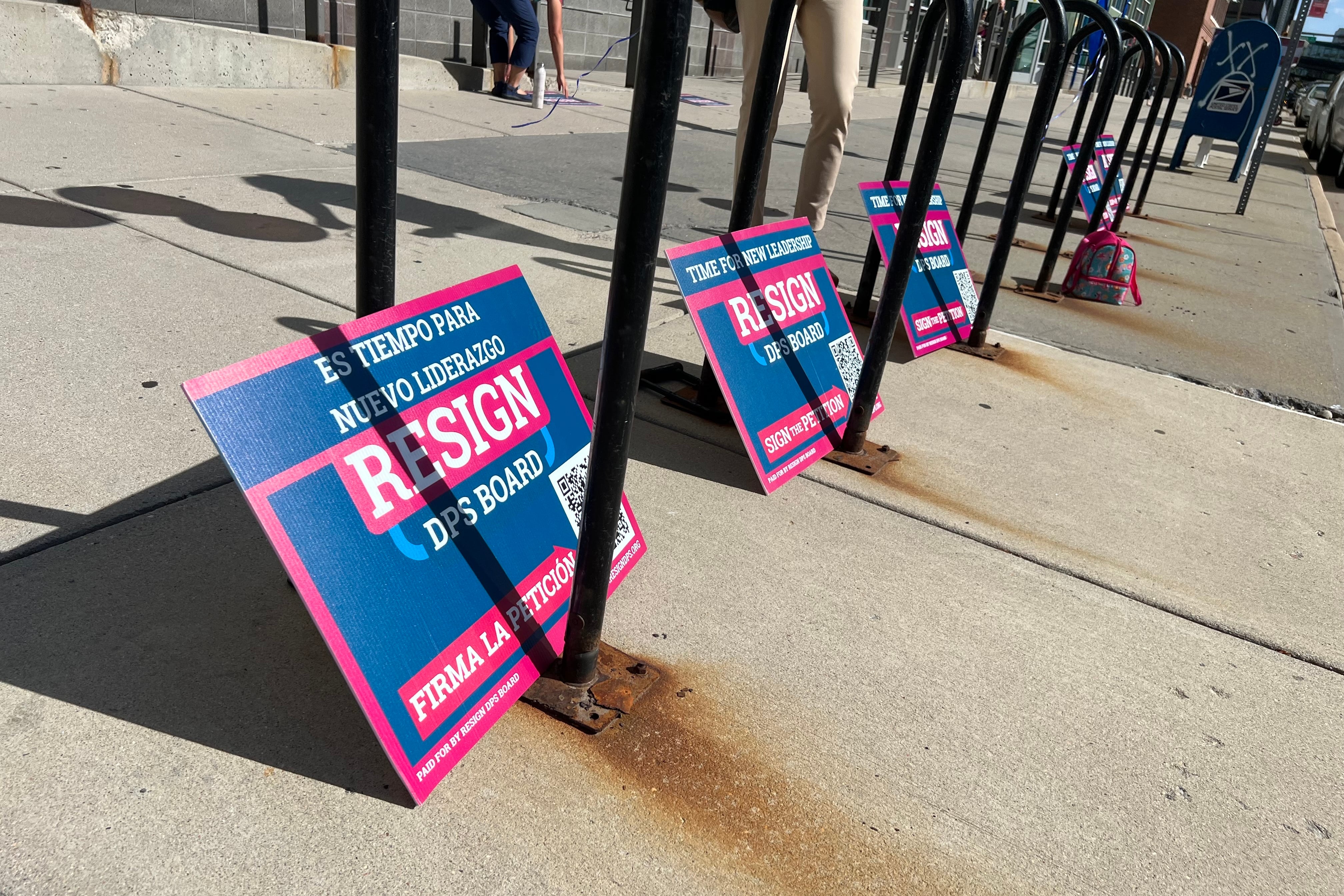 Lawn signs rest on a sidewalk