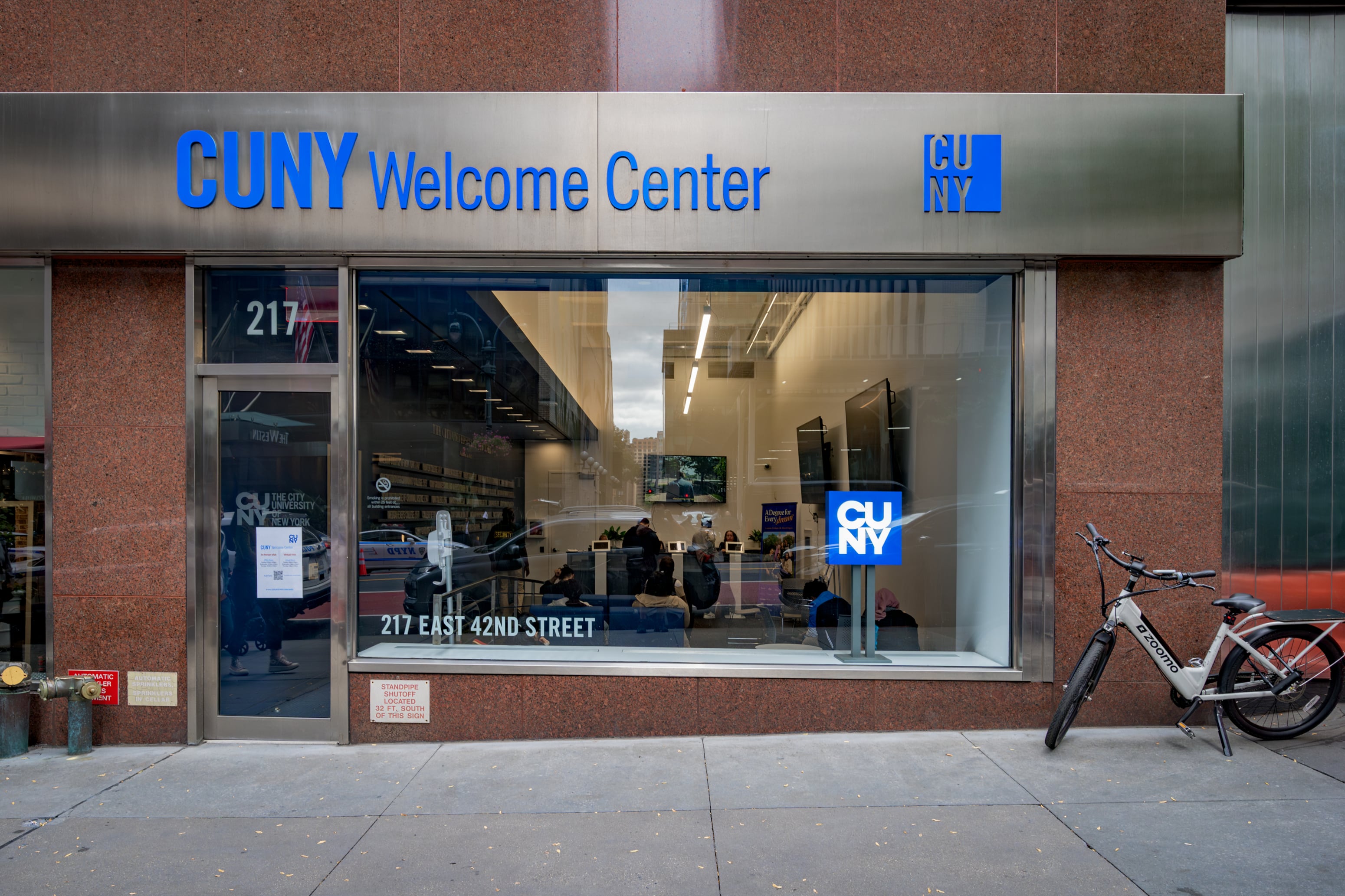 The front entrance to a building with a sign that reads "CUNY Welcome Center."
