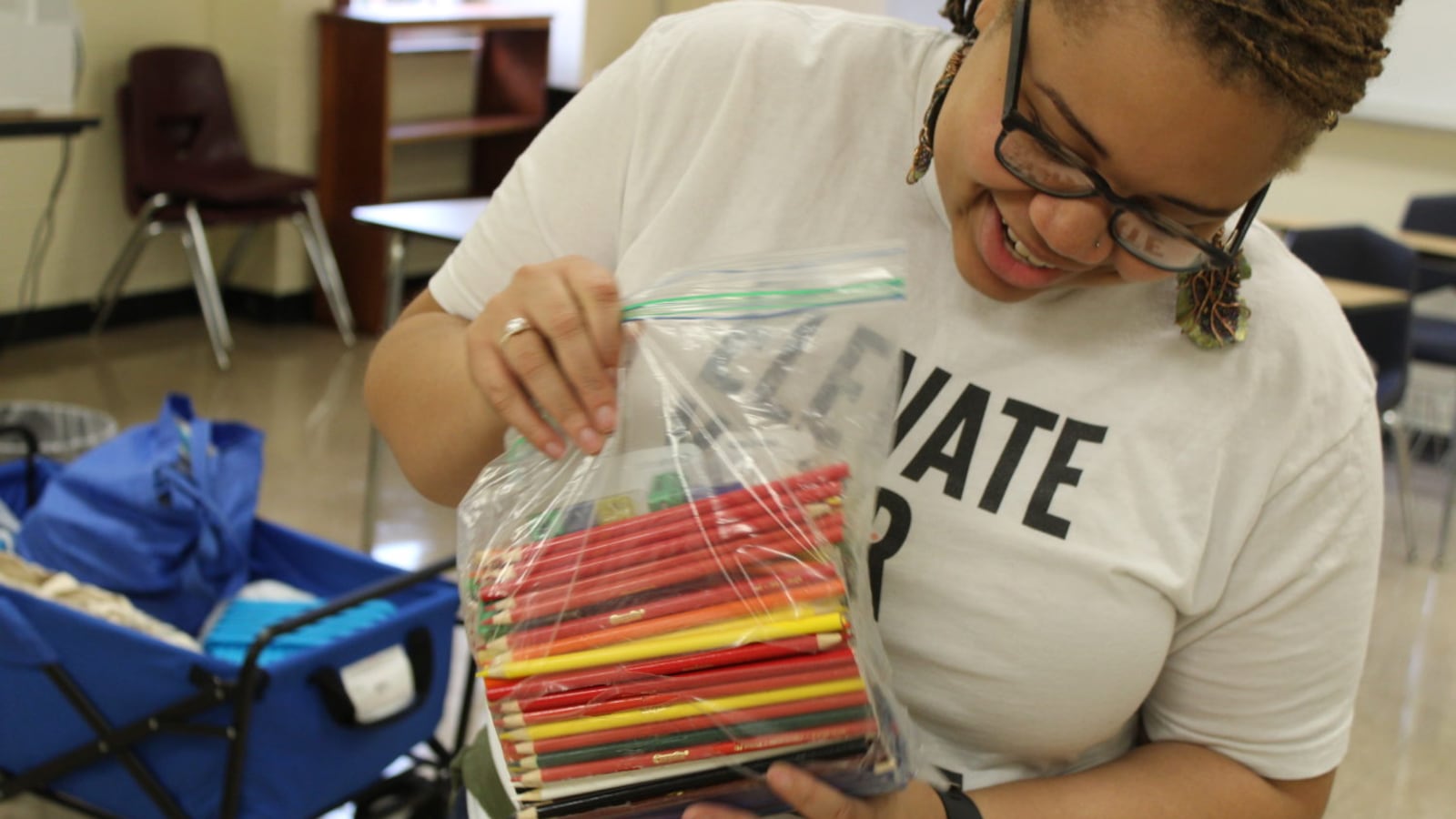 Shemena Shivers, a ninth grade science teacher at Melrose High School, smiles as she opens a package from a friend in Arizona. Through social media, Shivers has raised $1600 for her classroom.