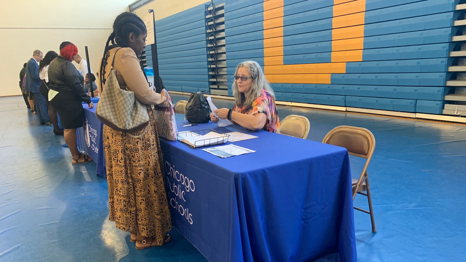 A district representative speaks to a candidate at the Chicago Public Schools job fair in the gymnasium of Richard J Daley College.