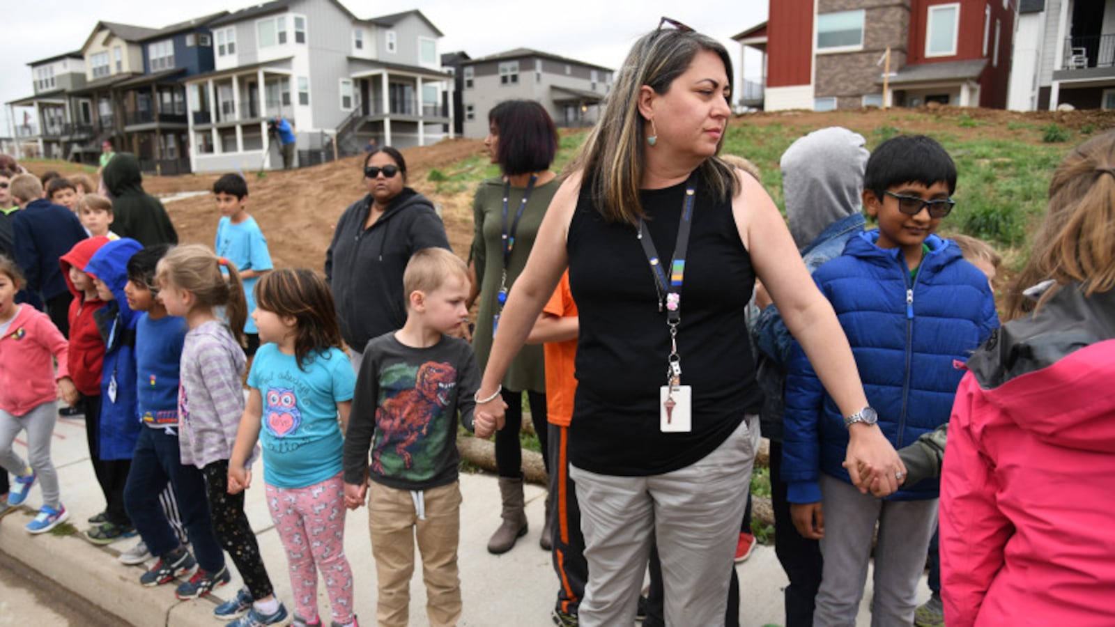 Students were escorted to school buses in front of STEM School Highlands Ranch after the shooting there.