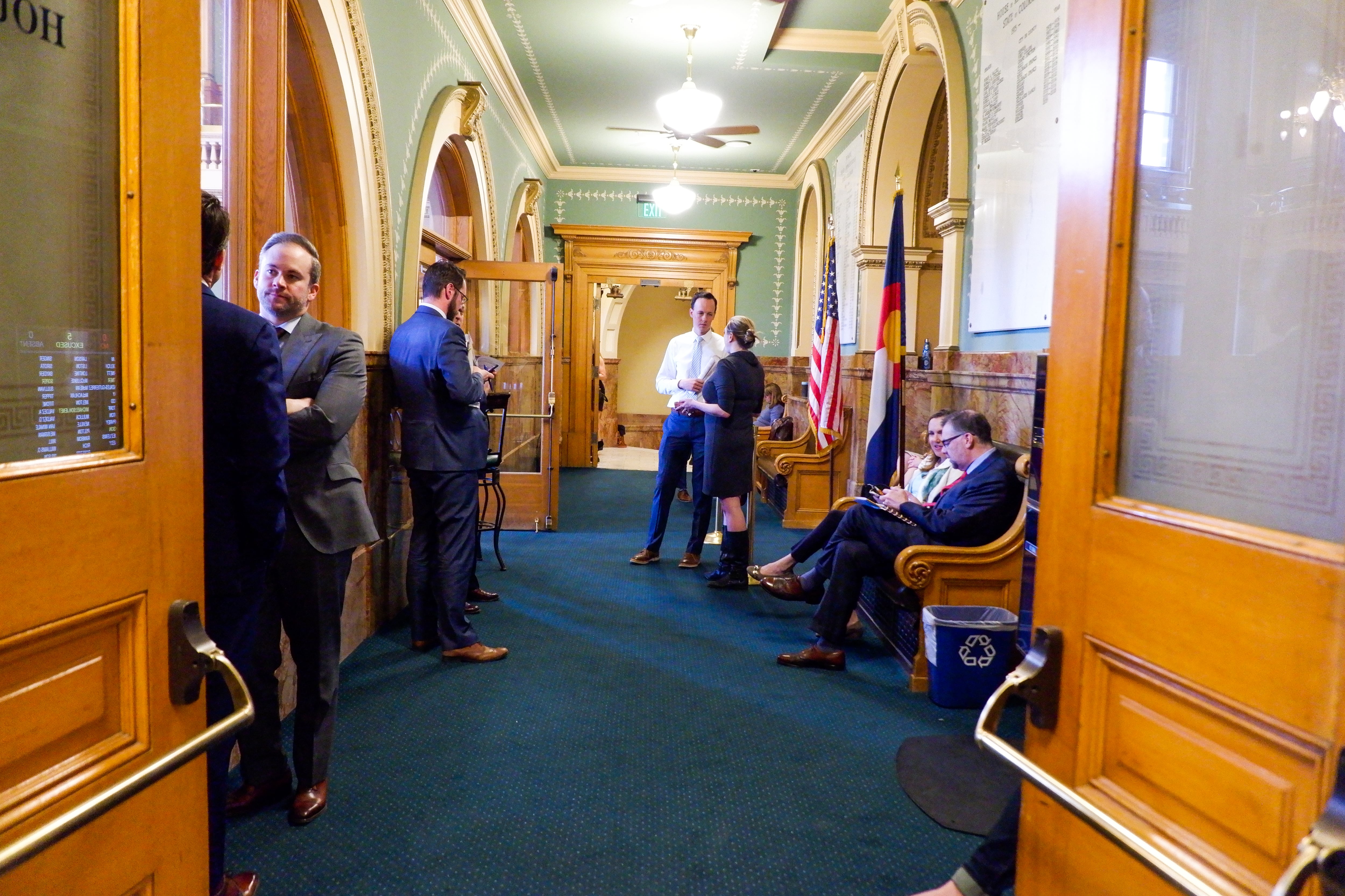 A half dozen lobbyists lean on walls and sit on benches in the lobby of the Colorado House of Representatives. 
