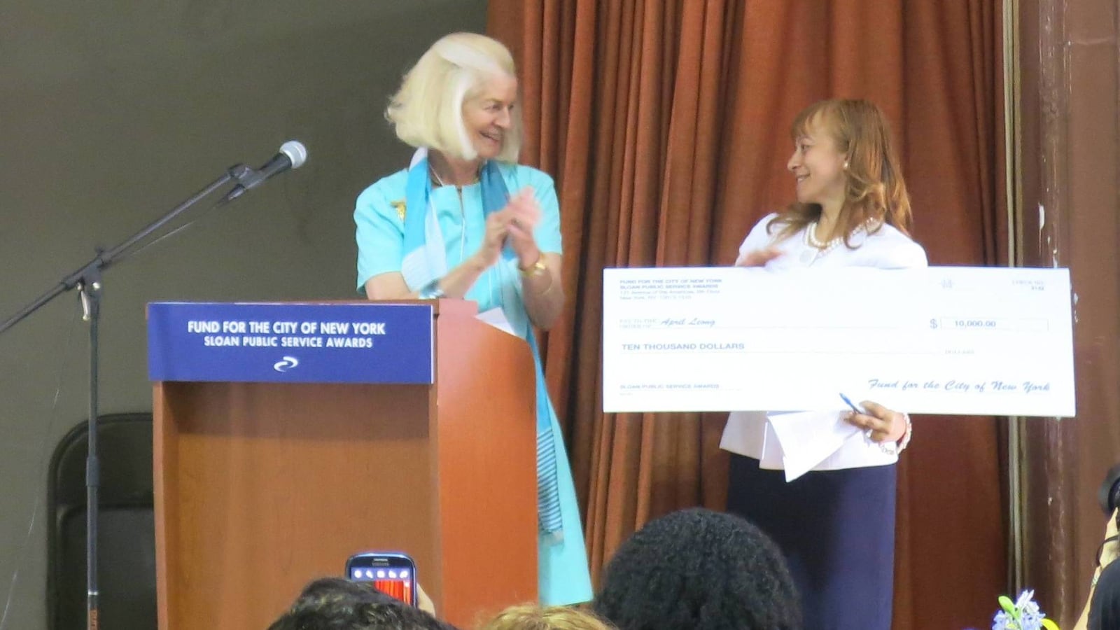 Liberation Diploma Plus High School Principal April Leong (right) receives her $10,000 check as a recipient of the 2014 Sloan Public Service Awards.