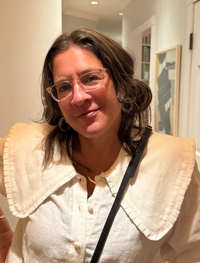 A woman with glasses in a white shirt