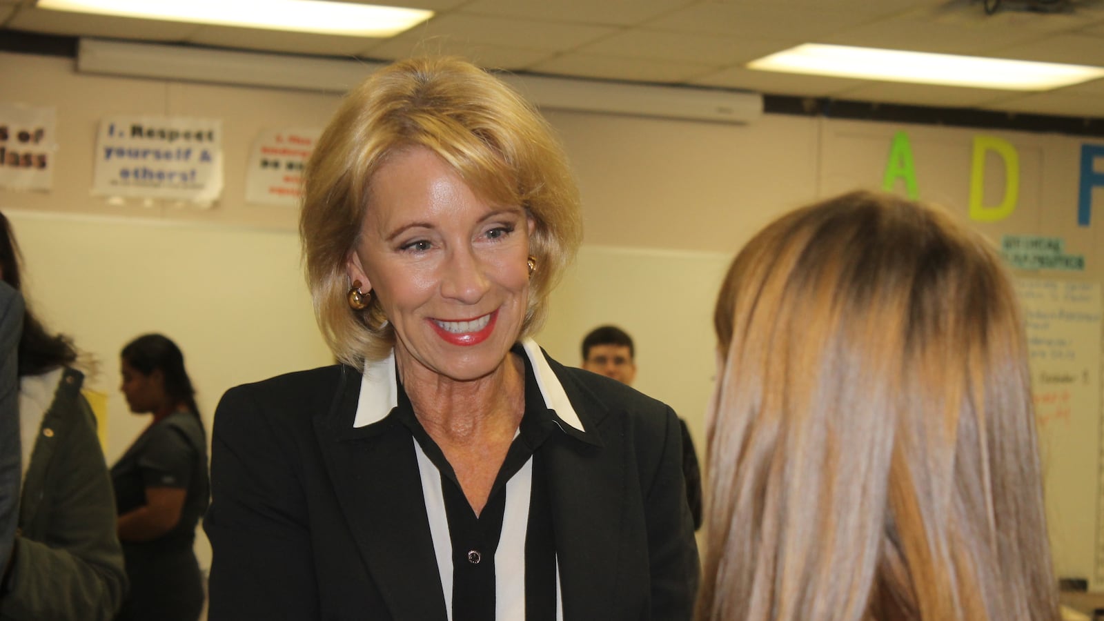Betsy DeVos talks with a student in a health sciences program at Oakland High School in Murfreesboro, Tennessee.