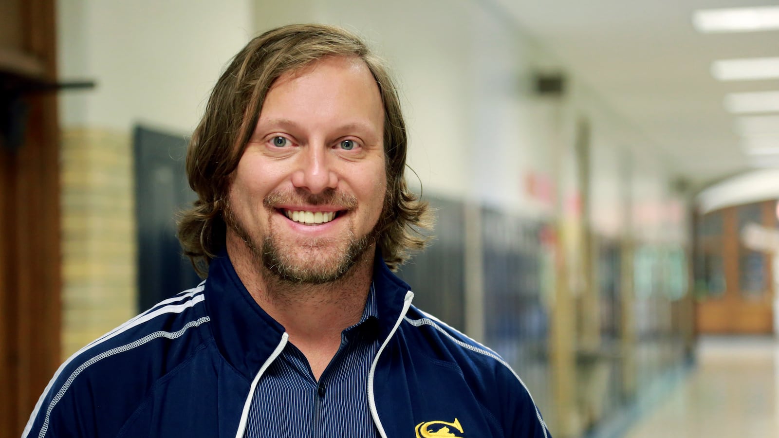 Chad Adams-Thomas, principal of Sullivan High School, stands in the hallway of one of the most diverse schools in the city.  He is one of 36 principals awarded fellowships on Thursday.