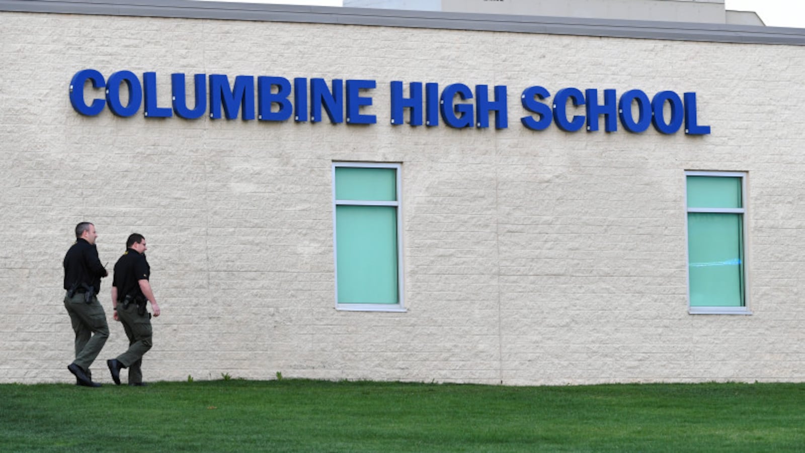 Officers walk around Columbine High School on April 17, 2019, as law enforcement searched for a woman who had traveled from Florida, motivated by an obsession with the 1999 shooting there.