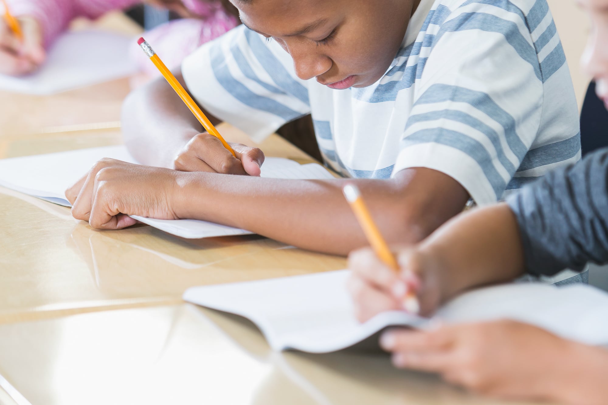 Students write with pencils.