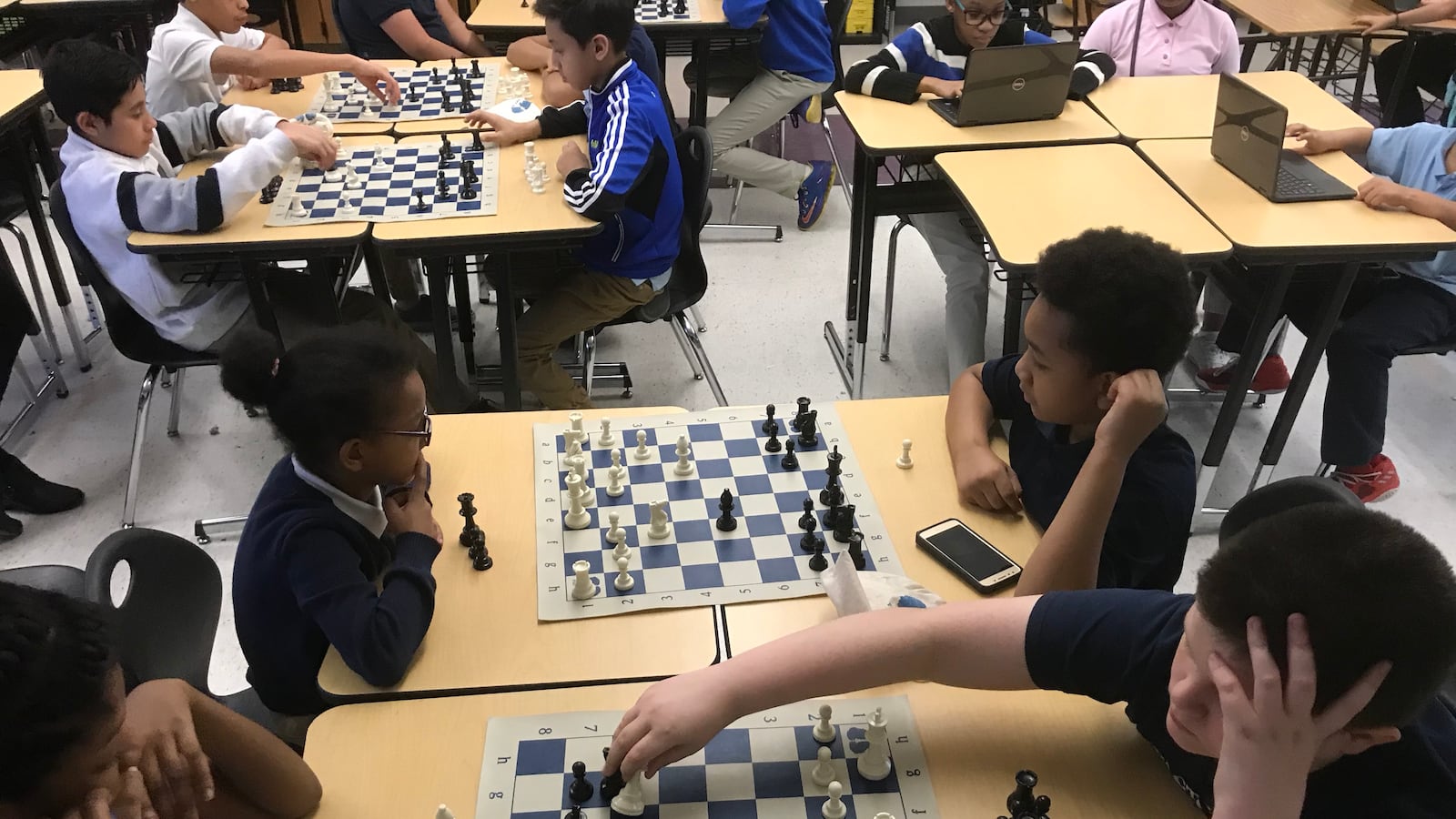 Mia Singleton, left, and Shaun Tinker, both in foreground, engage in a chess game during practice Tuesday at Munger Elementary-Middle School in Detroit