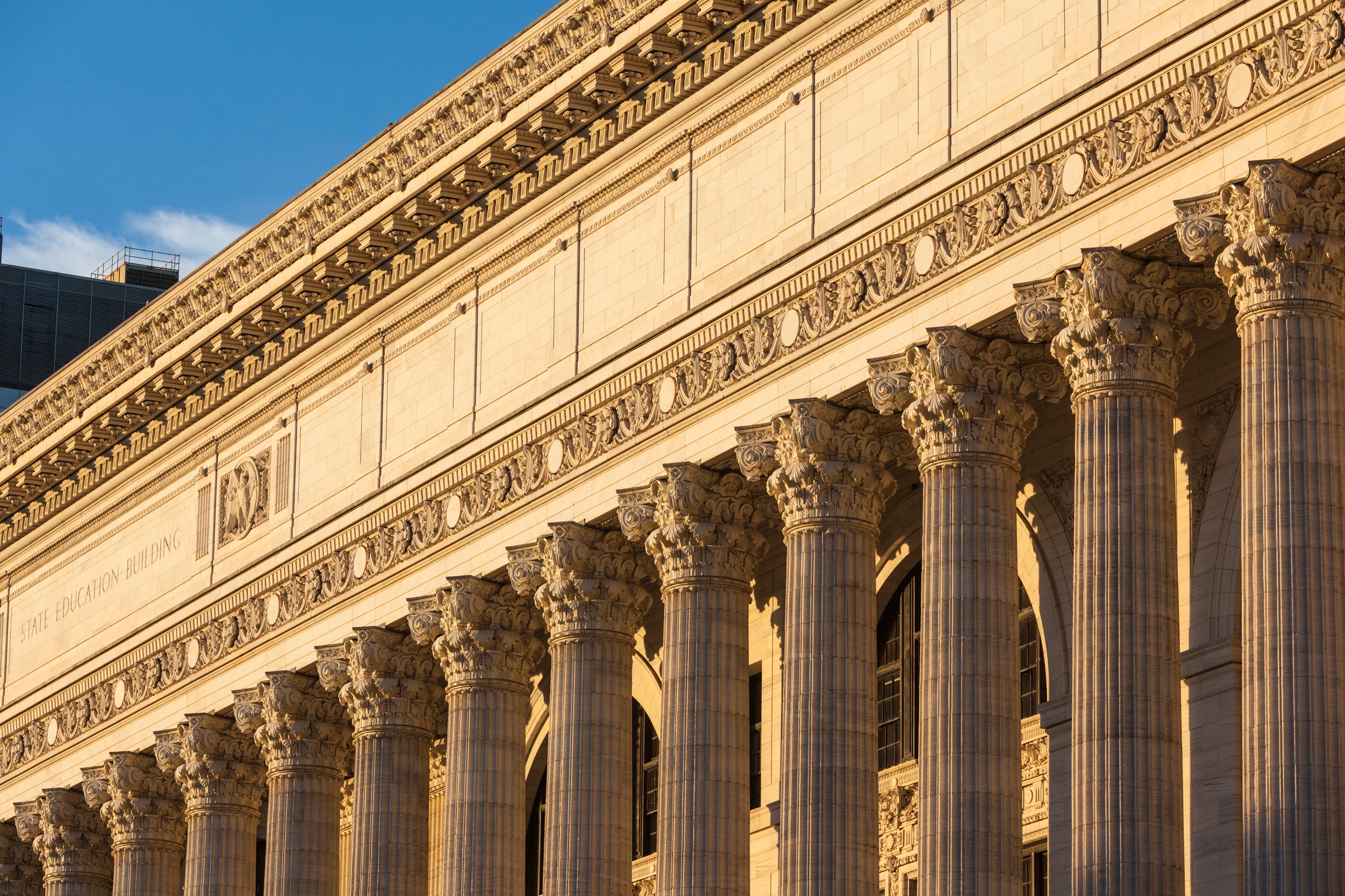 Warm sunlight hits the side of a large stone building.