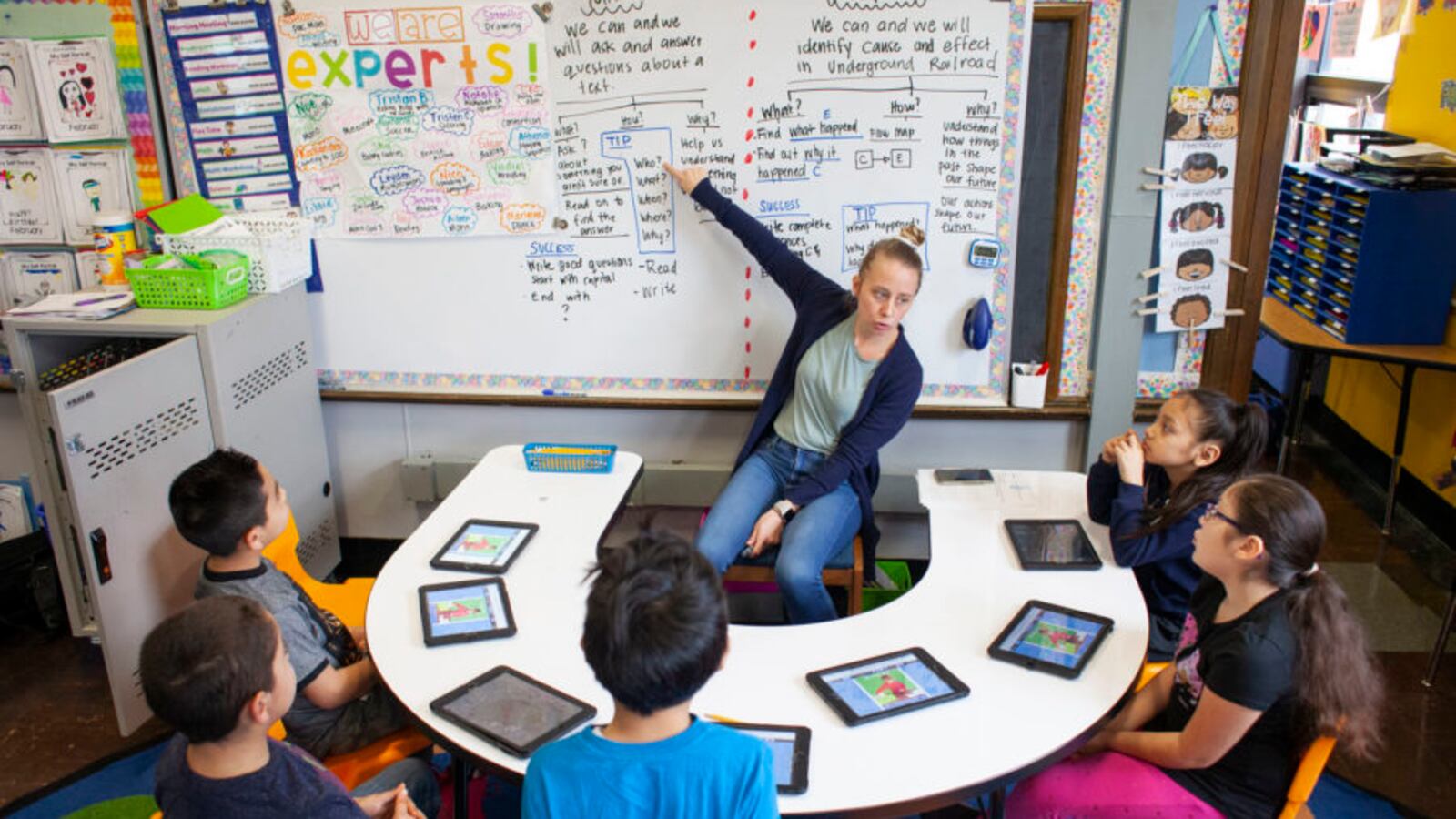 Teacher Kathy McInterney, center, spends intervals of time dedicated to teaching a specific group of students during class at CICS West Belden. The Chicago charter school employs the personalized learning method for its K-8 students.