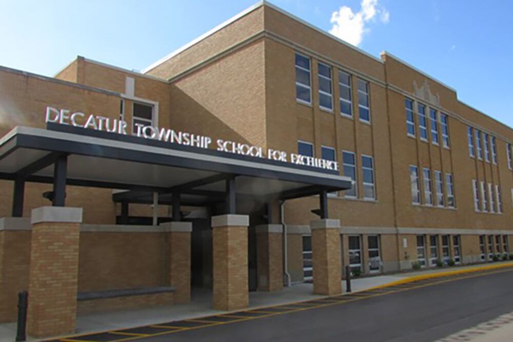 A large, tan stone building outside with a blue sky in the background.