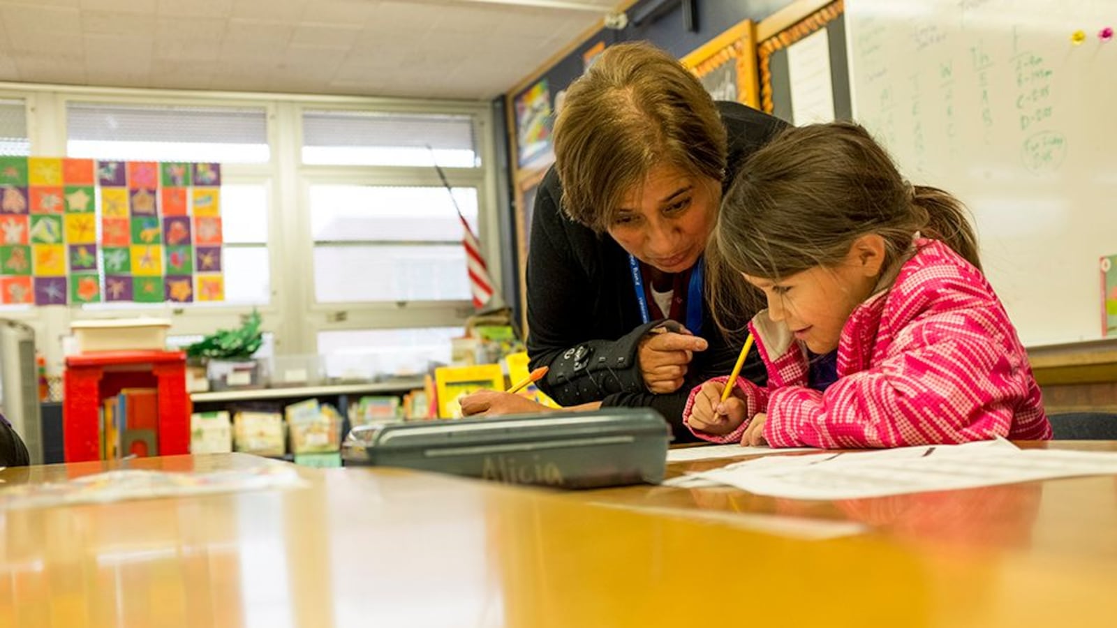 Paraprofessional Bertha Finney works with a first-grade student on a writing assignment at Denver's Goldrick Elementary School in 2017.