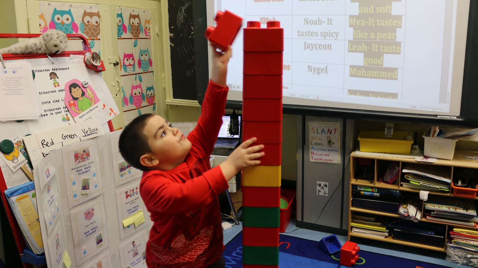 A pre-K student at P.S. 277 in the Bronx builds a block tower.