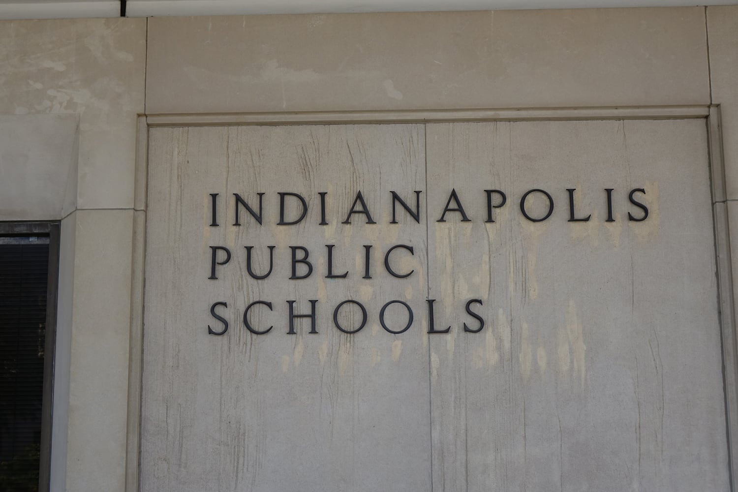 The side of a building has the words Indianapolis Public Schools set in the stone.