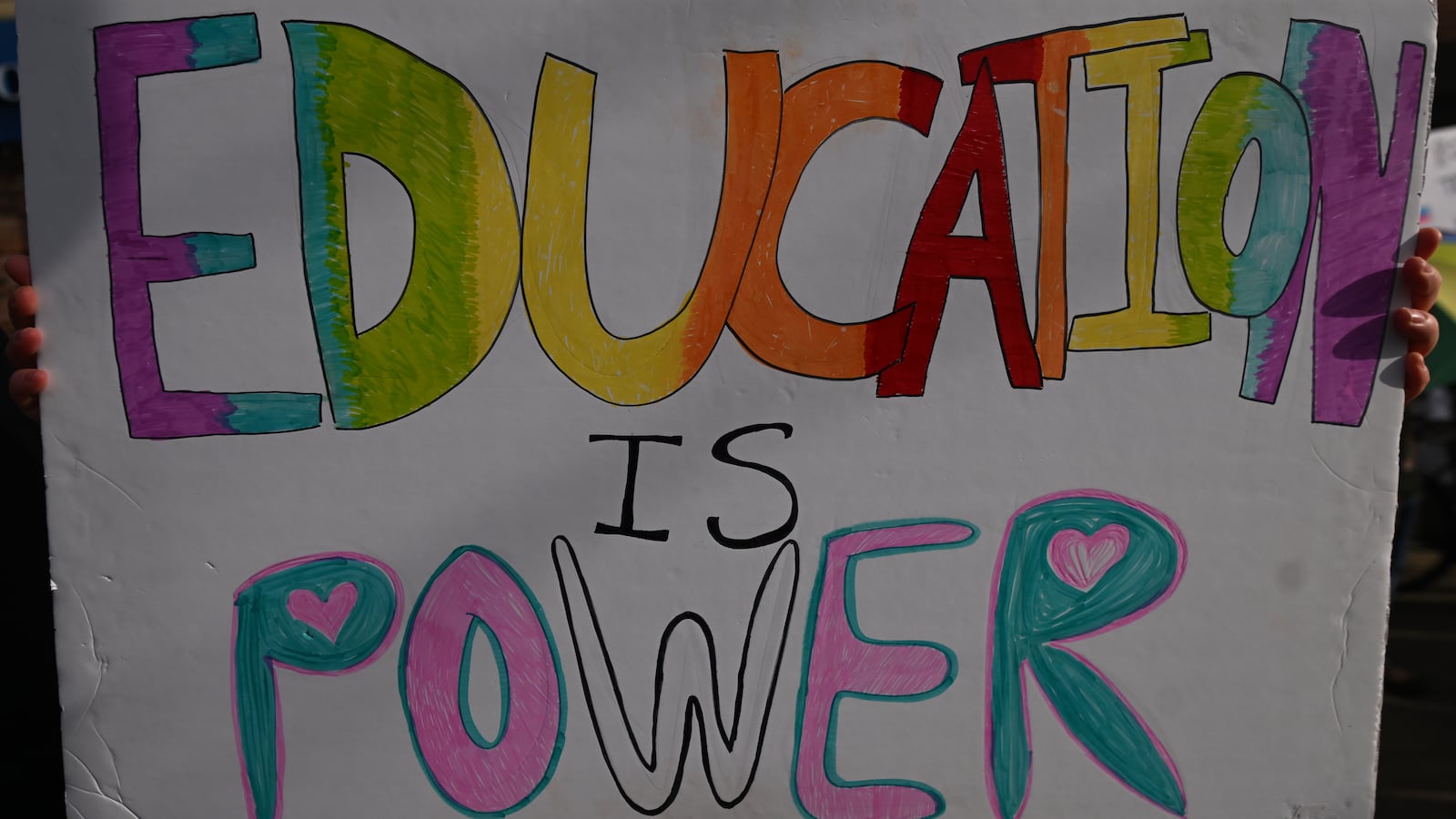 A hand-drawn poster that reads, in rainbow print, "Education is Power."