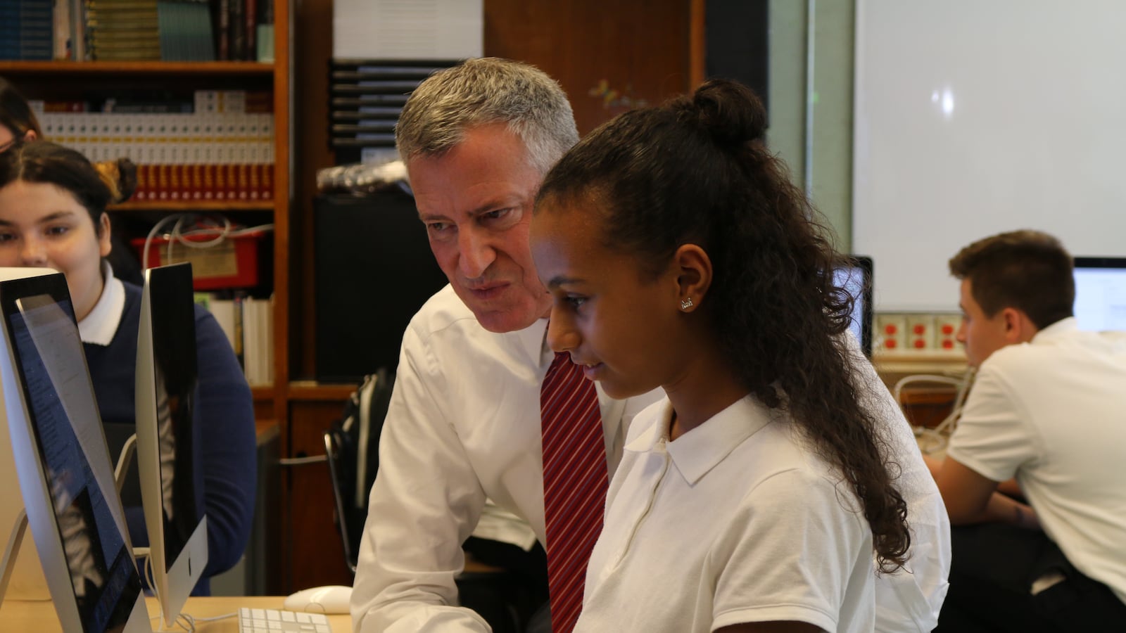 Mayor Bill de Blasio learns about computer science from a student at the Laboratory School of Finance and Technology in the Bronx.