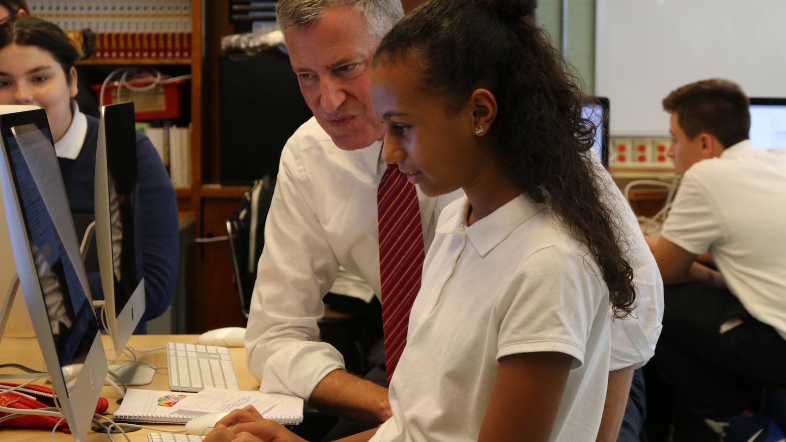 Mayor Bill de Blasio learns about computer science from a student at the Laboratory School of Finance and Technology in the Bronx.