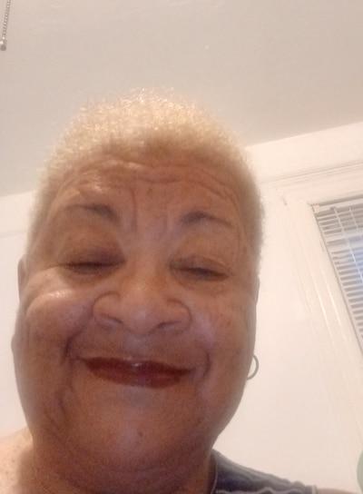 A person with short hair poses for a selfie inside.