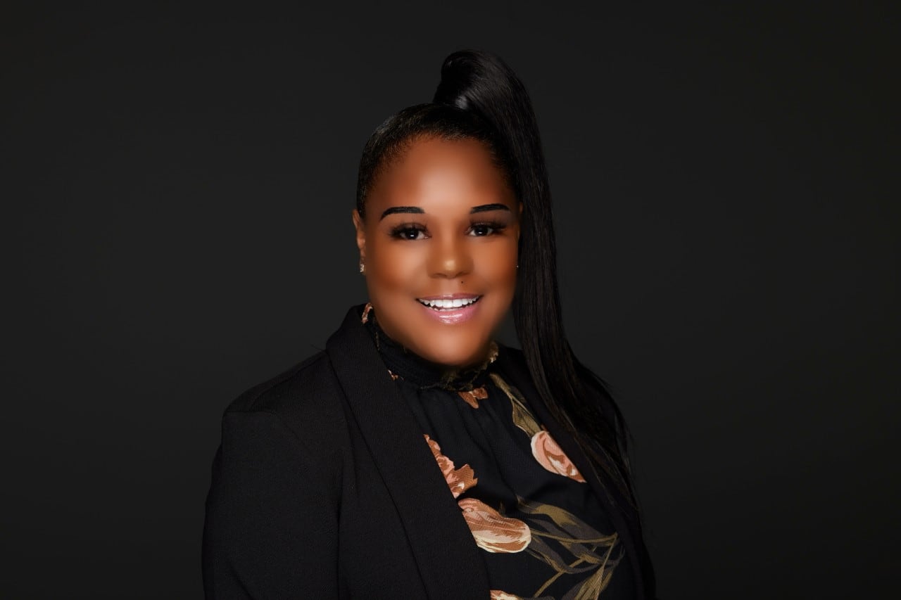 A woman in professional dress smiles at the camera for a headshot.