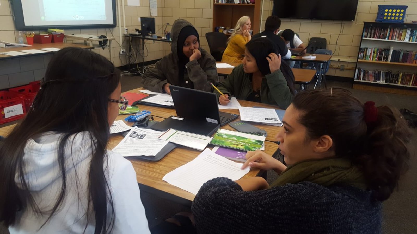 A teacher and a student teacher work with 9th grade students in an English Language Arts class at Aurora Central High School.
