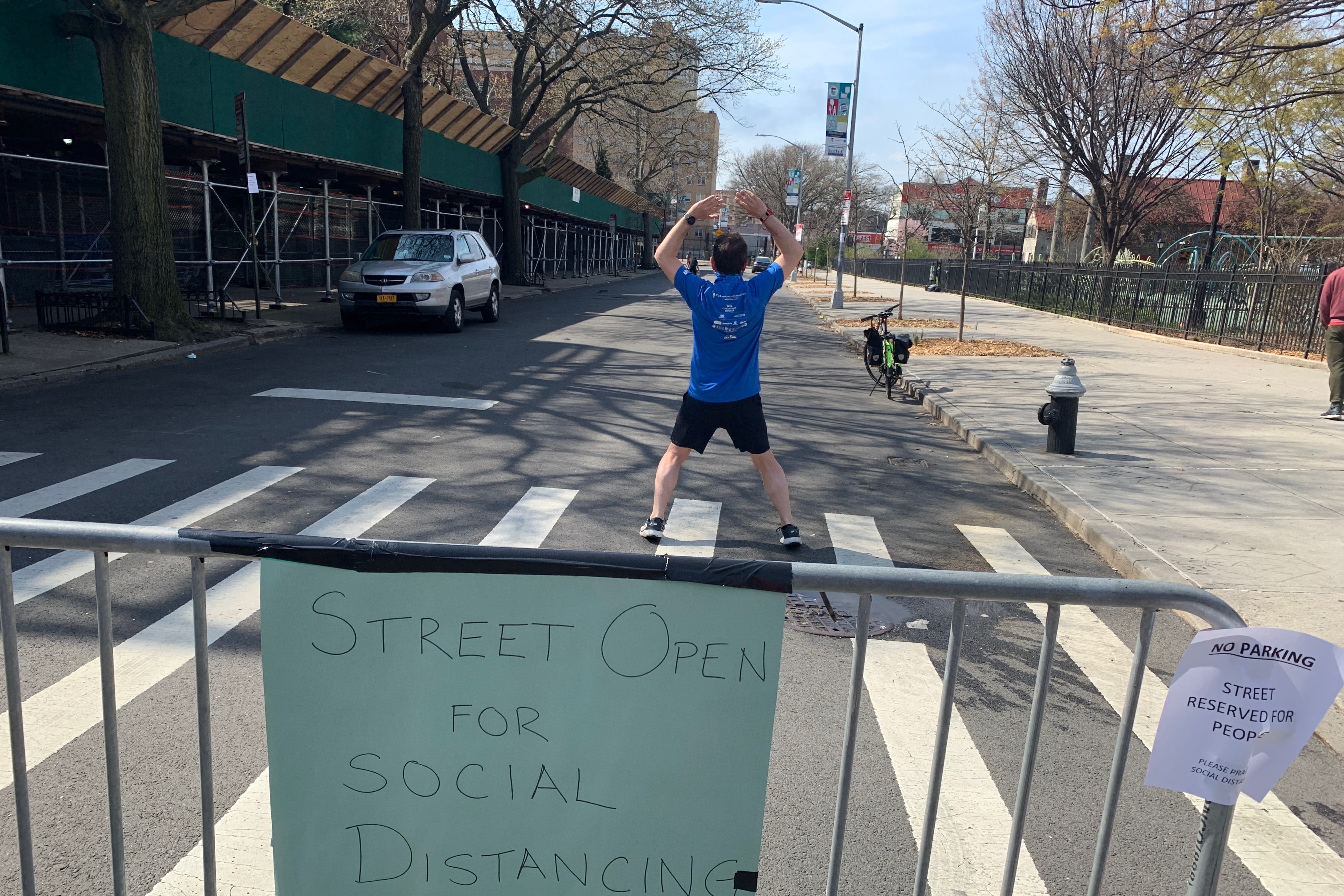A person exercises on a NYC street closed to traffic.