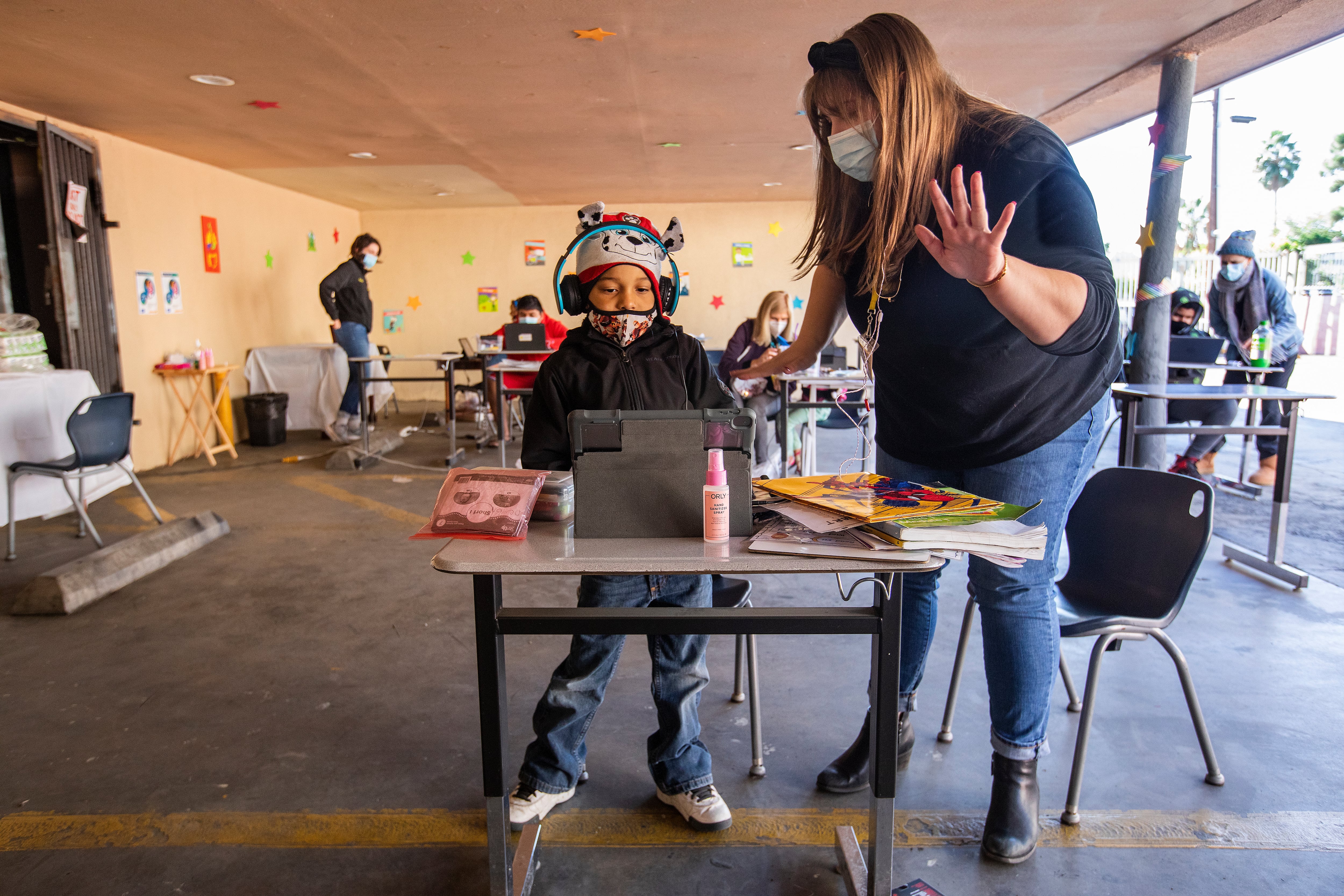 A volunteer helps a first-grade student learn math at a California learning pod for homeless children in November 2020.