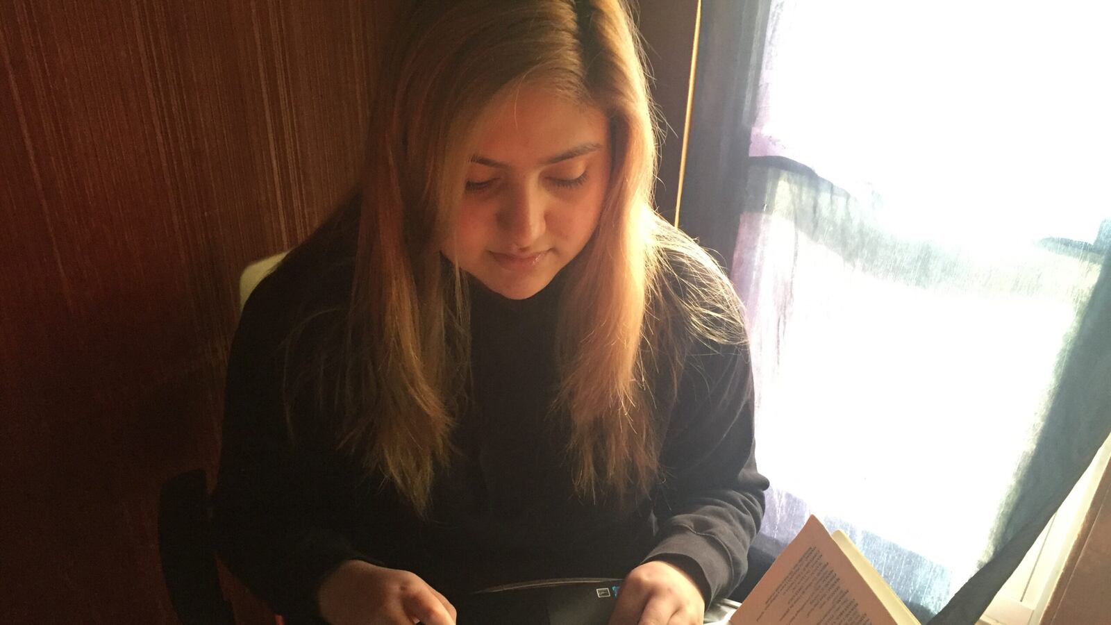 Yuliza Soto, a junior at Chicago's Prosser Career Academy, works on an assignment for an English class in her Belmont Cragin home.