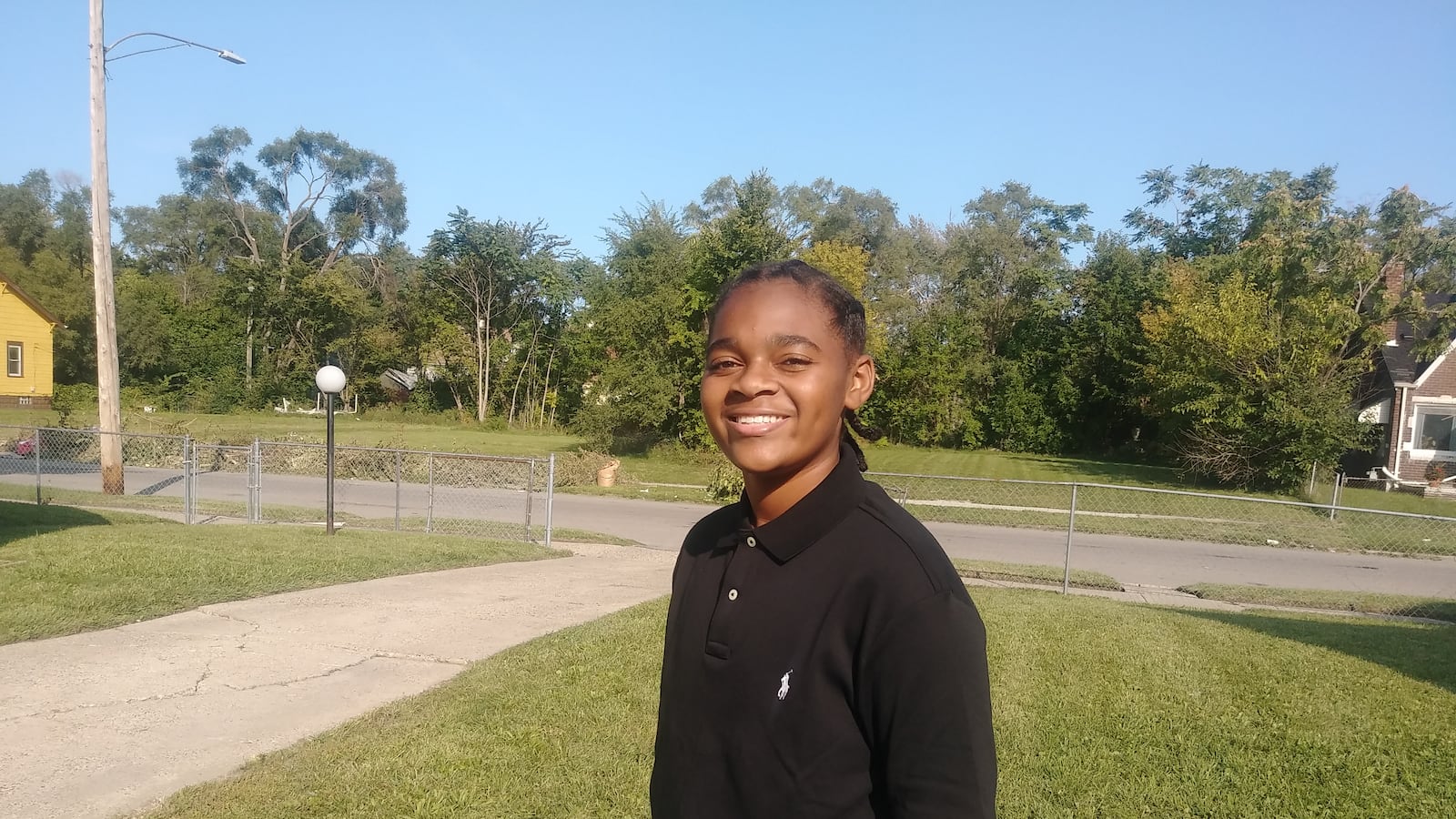 King Bethel standing outside on a sunny day smiling.