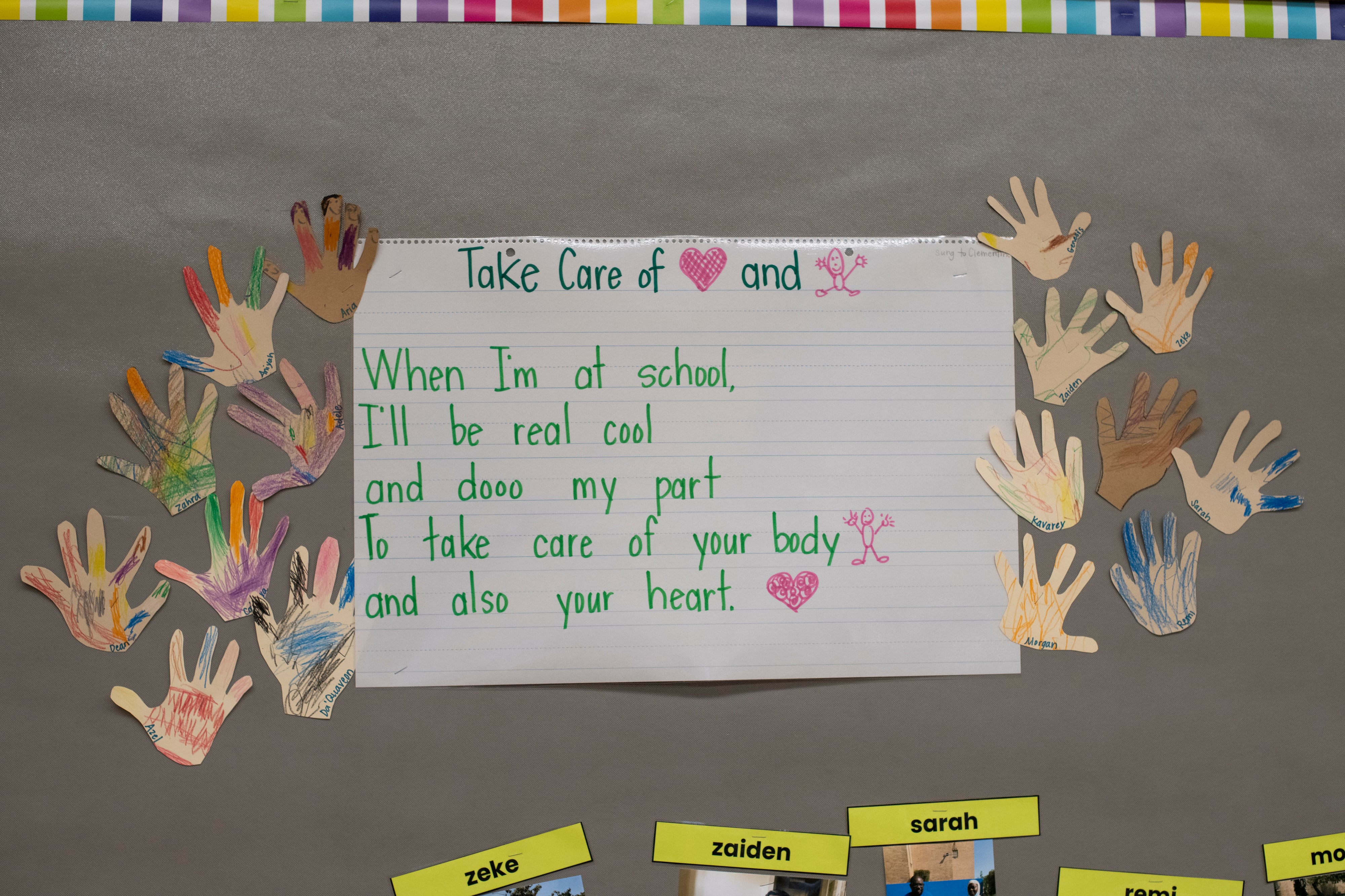 A photograph of a classroom board with a large song written on it and some other hand made decorations.